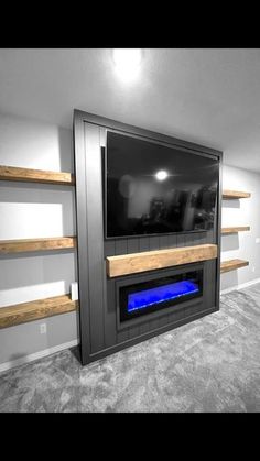 a television mounted on the wall in a living room with shelves and a fire place