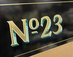 a close up of the number two on a black and gold plated metal sign