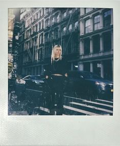 a polaroid photograph of a woman standing in the street