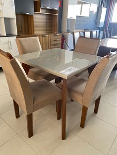 a glass table with chairs around it in a room that has white tile flooring