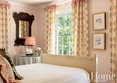 a bedroom with pink walls and floral curtains