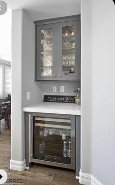 a kitchen with gray cabinets and white counter tops, an oven built into the wall