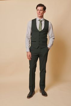 As worn by Leicester City midfielder Harry Winks! This stately three-piece suit for discerning gentlemen is a distinguished selection for formal occasions, like nuptials. Its timeless Prince of Wales check motif exudes elegance, while the elastane blend ensures ease of movement and comfort. The olive green hue accentuates any refined look. Model wears size 38R blazer, 38R waistcoat & 30R trousers. Features Slim fit Single-breasted waistcoat Prince of Wales check Notch lapel Single back vent Four Tailored Dapper Three-piece Suit, Dapper Tailored Three-piece Suit With Notch Lapel, Classic Green Double Breasted Suit For Groom, Custom Fit Three-piece Suit With Notch Lapel For Semi-formal, Semi-formal Three-piece Suit With Notch Lapel, Custom Fit Three-piece Suit For Semi-formal Occasions, Green Fitted Three-piece Suit For Groom, Fitted Green Three-piece Suit For Groom, Fitted Green Three-piece Suit For Grooms