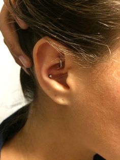 a close up of a person's ear with a ring on top of it