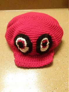 a red knitted hat with two large eyes