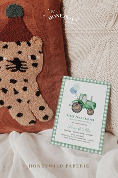 a pillow with a teddy bear and tractor on it next to a card that reads, save the date