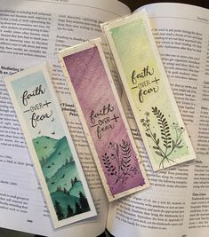 three bookmarks that are sitting on top of an open book