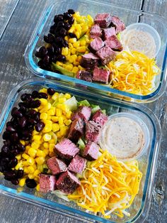 two plastic containers filled with meat and veggies on top of a wooden table