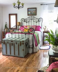 a bed room with a guitar on the floor next to a rug and a table