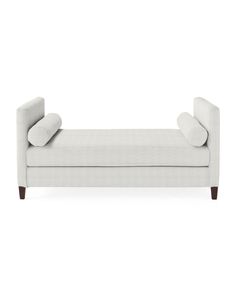 a white couch sitting on top of a white floor next to a wooden leg chair