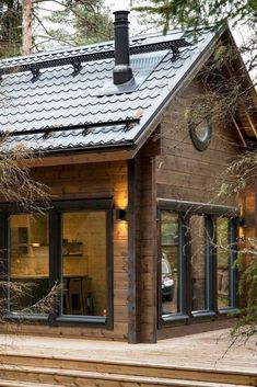 a small wooden cabin in the woods with stairs leading up to it's front door