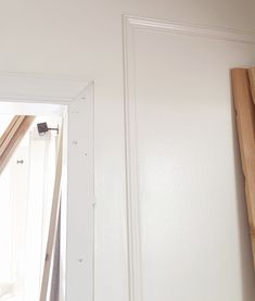 an open door in a room with white walls and wood trim on the outside wall