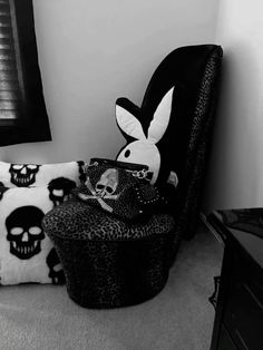 a black and white photo of a chair with a bunny pillow on top of it