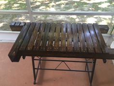 a bench made out of wooden slats sitting in front of a window