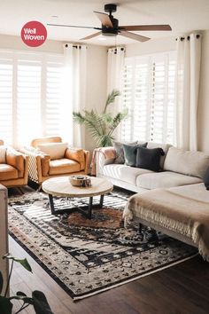 a living room with couches, chairs and a rug in front of the windows