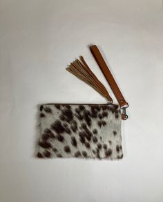 a brown and white animal print purse with tassels