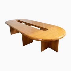 a wooden table with an oval shaped top and two curved legs, on white background