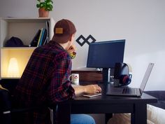 a man sitting at a desk using a laptop computer