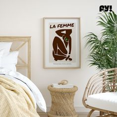 a bedroom with a bed, wicker chair and poster on the wall above it