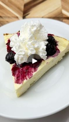 a slice of cheesecake topped with whipped cream and berries