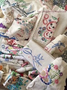 many different types of embroidered cloths are stacked on top of each other in a pile