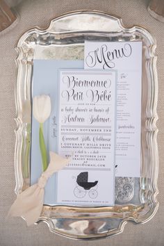 a wedding menu is displayed in a silver frame on the back of a chair with tulips