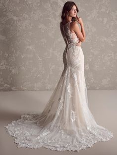 a woman in a wedding dress posing for the camera with her back to the camera