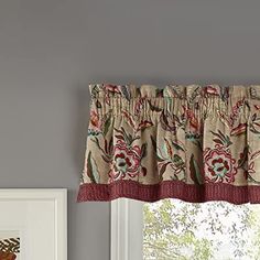 a window with a curtain and valance in front of the window is decorated with flowers