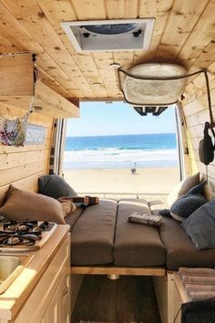 the inside of a camper van with a bed and sink in front of it