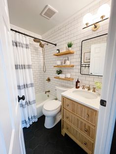 a bathroom with black and white tile flooring, wooden cabinetry, and open shelving above the toilet