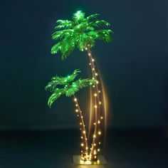 a lighted palm tree on a stand with lights in the shape of three trunks and two leaves