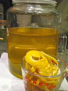 a glass jar filled with yellow liquid next to a container full of oil