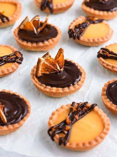 chocolate and orange tarts are arranged on wax paper