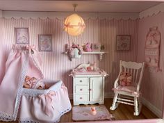 a doll's room with pink walls, furniture and accessories in the shape of a baby crib