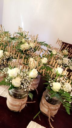 several vases filled with white flowers on top of a table