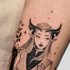 a tattoo on the arm of a woman with horns