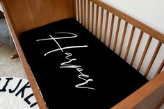 a baby crib with a black blanket that says faith