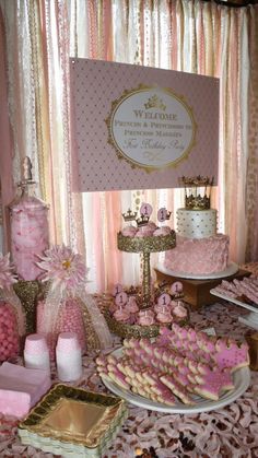 a table topped with lots of pink and gold desserts