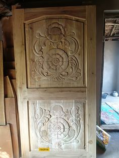 two wooden doors with carvings on them in a room filled with wood planks and plywood