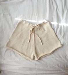 a pair of white shorts laying on top of a bed