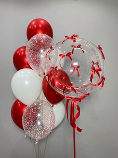 red and white balloons with streamers on the wall