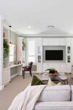 a living room filled with furniture and a flat screen tv mounted to the wall above it