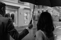 a man and woman holding an umbrella in the rain