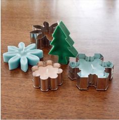 four cookie cutters are sitting on a table with a christmas tree in the middle