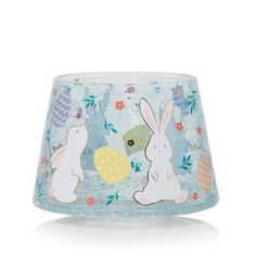 a glass candle holder with two rabbits on it