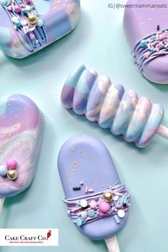 some kind of colorful lollipops on a blue table with gold and pink decorations