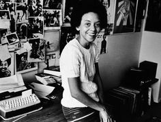 a black and white photo of a woman sitting at a desk