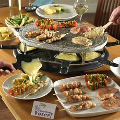 an assortment of food is being prepared on a table with wine glasses and utensils