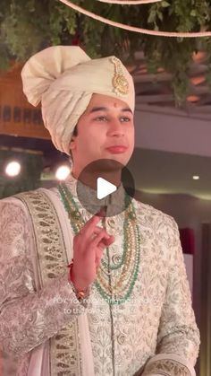 a man wearing a turban and holding a piece of food