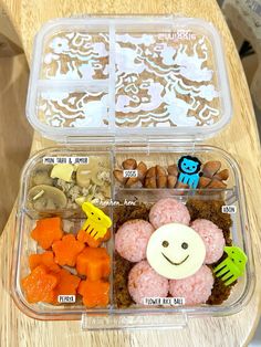 a plastic container filled with food on top of a wooden table